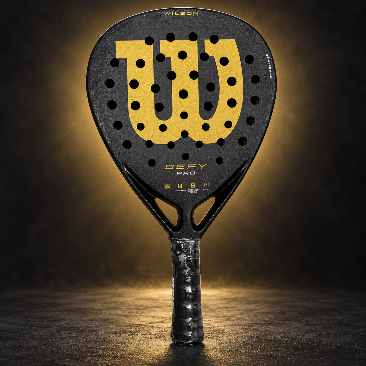 Wilson Defy Pro racket on dark gold studio background